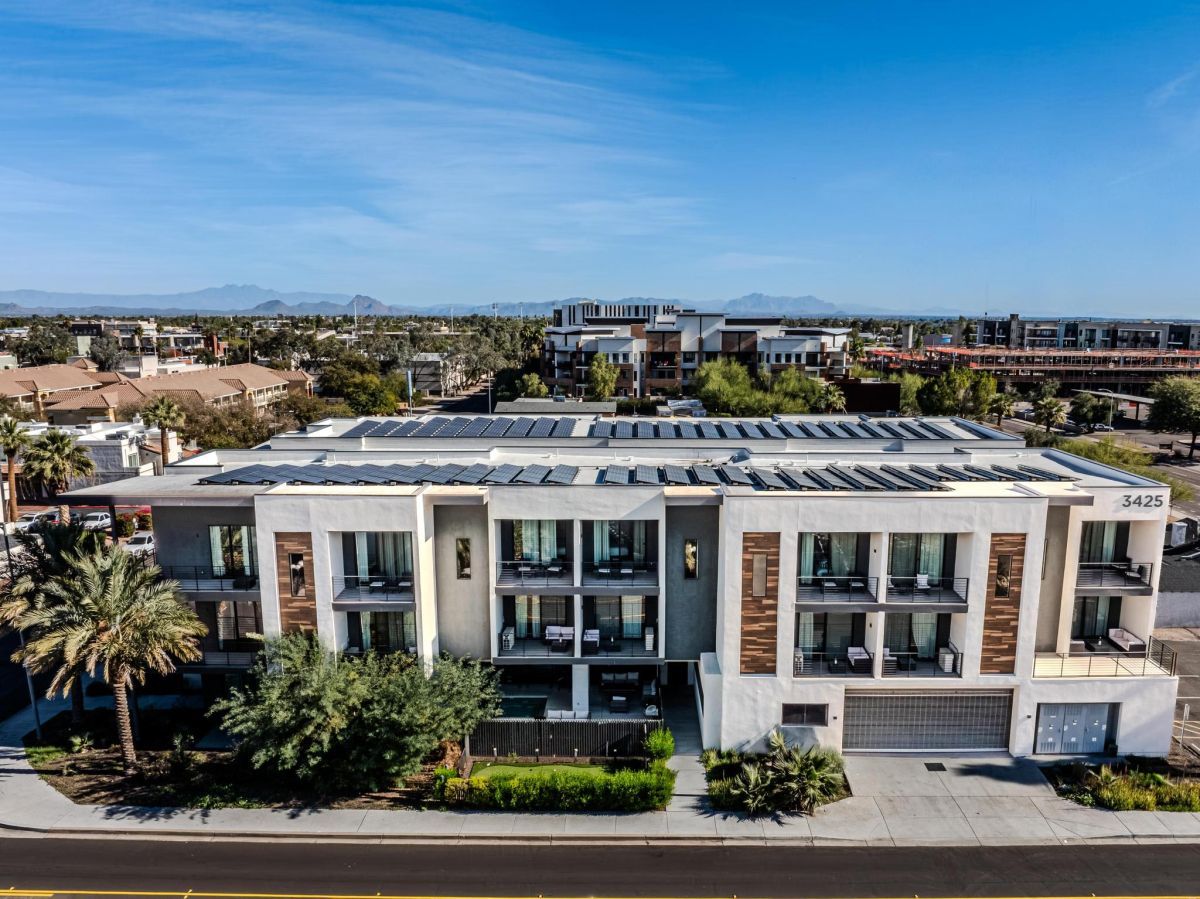 Modern white apartment building with multiple balconies, palm trees along the sidewalk, and solar panels on the roof under a bright blue sky with distant mountains. Address number 3425 visible on the facade.]','A contemporary residential complex with glass-front balconies, landscaped greenery, and a wide street in front, set against a clear desert sky.